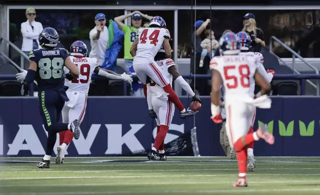 EDS NOTE: OBSCENITY - New York Giants wide receiver Bryce Ford-Wheaton (88), back, center, celebrates with teammates after returning a blocked field goal for a touchdown during the second half of an NFL football game against the Seattle Seahawks, Sunday, Oct. 6, 2024, in Seattle. (AP Photo/John Froschauer)