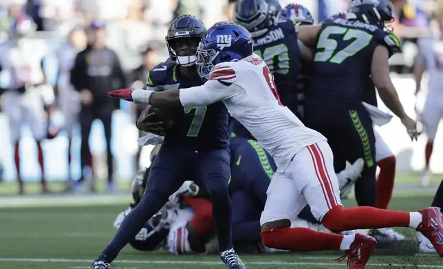 Seattle Seahawks quarterback Geno Smith (7) is sacked by New York Giants linebacker Brian Burns (0) during the second half of an NFL football game, Sunday, Oct. 6, 2024, in Seattle. (AP Photo/John Froschauer)