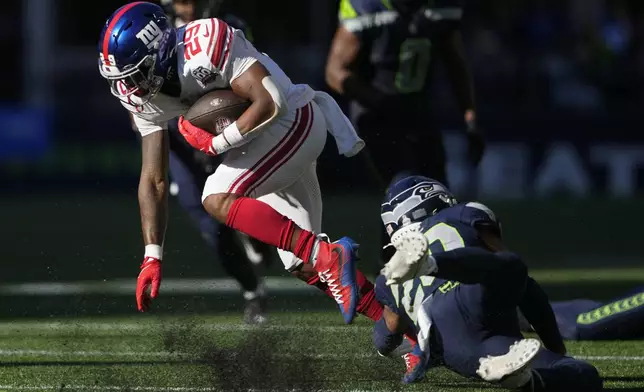 New York Giants running back Tyrone Tracy Jr. (29) runs with the football as Seattle Seahawks safety Julian Love (20) tries to tackle during the second half of an NFL football game, Sunday, Oct. 6, 2024, in Seattle. (AP Photo/Lindsey Wasson)