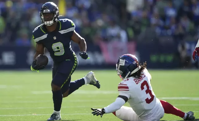 Seattle Seahawks running back Kenneth Walker III (9) runs with football as New York Giants cornerback Deonte Banks (3) tries to tackle during the second half of an NFL football game, Sunday, Oct. 6, 2024, in Seattle. (AP Photo/Lindsey Wasson)