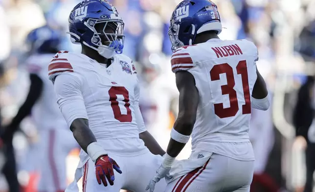 New York Giants linebacker Brian Burns (0) celebrates with teammate safety Tyler Nubin (31) after sacking Seattle Seahawks quarterback Geno Smith (7) during the second half of an NFL football game, Sunday, Oct. 6, 2024, in Seattle. (AP Photo/John Froschauer)