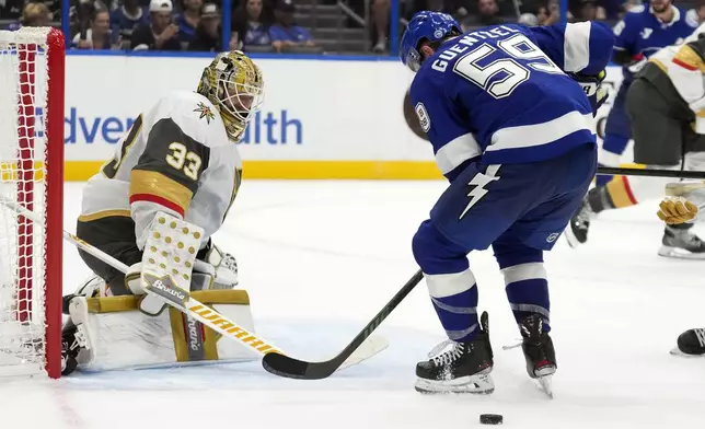 Vegas Golden Knights goaltender Adin Hill (33) makes a save on a shot by Tampa Bay Lightning center Jake Guentzel (59) during the second period of an NHL hockey game Thursday, Oct. 17, 2024, in Tampa, Fla. (AP Photo/Chris O'Meara)