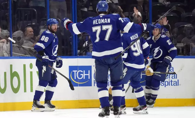 Tampa Bay Lightning right wing Nikita Kucherov (86) celebrates his goal against the Vegas Golden Knights with teammates, including defenseman Victor Hedman (77) and defenseman Janis Moser (90) during the first period of an NHL hockey game Thursday, Oct. 17, 2024, in Tampa, Fla. (AP Photo/Chris O'Meara)