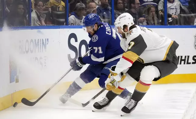 Tampa Bay Lightning center Anthony Cirelli (71) tries to work around Vegas Golden Knights defenseman Alex Pietrangelo (7) during the second period of an NHL hockey game Thursday, Oct. 17, 2024, in Tampa, Fla. (AP Photo/Chris O'Meara)