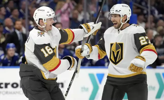 Vegas Golden Knights left wing Pavel Dorofeyev (16) celebrates his goal against the Tampa Bay Lightning with defenseman Shea Theodore (27) during the first period of an NHL hockey game Thursday, Oct. 17, 2024, in Tampa, Fla. (AP Photo/Chris O'Meara)