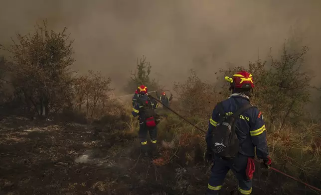Firefighters operate during a third day of a wildfire, in Sofiana village, about 142 kilometers (88 miles) west of Athens, Greece, on Tuesday, Oct. 1, 2024. (AP Photo/Petros Giannakouris)