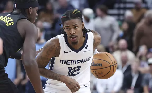 Memphis Grizzlies guard Ja Morant (12) holds the ball against the Utah Jazz during the first half of an NBA basketball game, Wednesday, Oct. 23, 2024, in Salt Lake City. (AP Photo/Rob Gray)