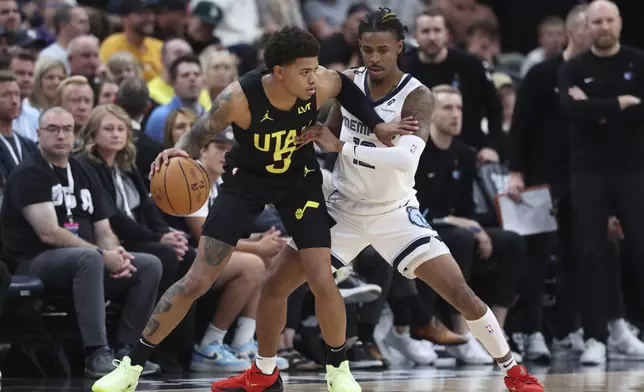 Utah Jazz guard Keyonte George (3) dribbles the ball while Memphis Grizzlies guard Ja Morant (12) defends during the first half of an NBA basketball game, Wednesday, Oct. 23, 2024, in Salt Lake City. (AP Photo/Rob Gray)