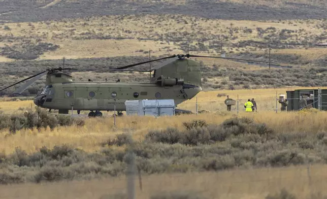 Crew members move boxes from a U.S. Army Chinook helicopter into a cargo container at Vagabond Army Heliport on Friday, Oct. 18, 2024, in Yakima, Wash. (Nick Wagner/The Seattle Times via AP)