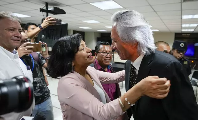 A lawyer greets Guatemalan journalist Jose Ruben Zamora, founder of El Periodico newspaper, jailed for more than two years on money laundering charges, as he exits a courthouse after a judge granted him house arrest, in Guatemala City, Friday, Oct. 18, 2024. (AP Photo/Moises Castillo)