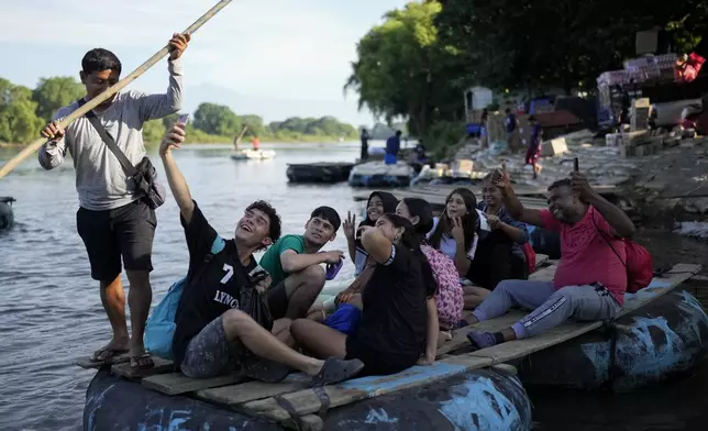 A Venezuelan migrant takes a selfie on a raft crossing the Suchiate River from Tecun Uman, Guatemala, to Mexico, Tuesday, Oct. 29, 2024. (AP Photo/Matias Delacroix)