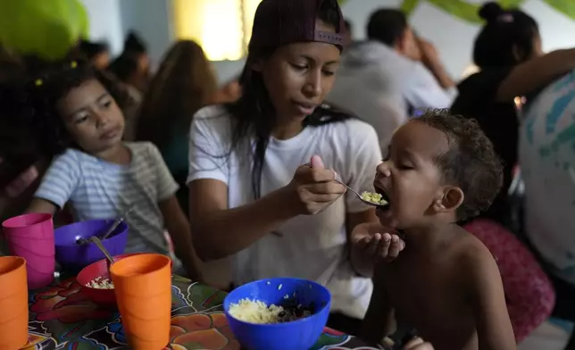 Venezuelan migrant Eyla Fonseca feeds breakfast to her son Keilerth Veloz at the Casa del Migrante shelter in Tecun Uman, Guatemala, Sunday, Oct. 27, 2024. (AP Photo/Matias Delacroix)