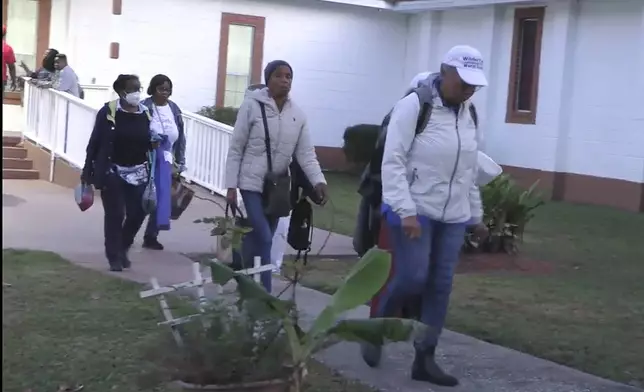 Festival goers who attended a Gullah Geechee festival on Sapelo Island leave the Elm Grove Church where they were taken to reunite with loved ones on Sapelo Island, Ga in McIntosh county, Sunday, Oct. 20, 2024. (AP Photo/Lewis M. Levine)