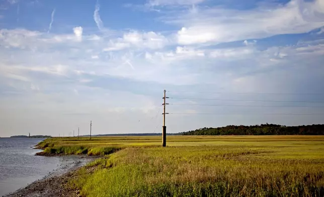 FILE - In this May 16, 2013, file photo, a utility pole stands in the middle of a marsh at sunset on Sapelo Island, Ga., a Gullah-Geechee community. (AP Photo/David Goldman, File)