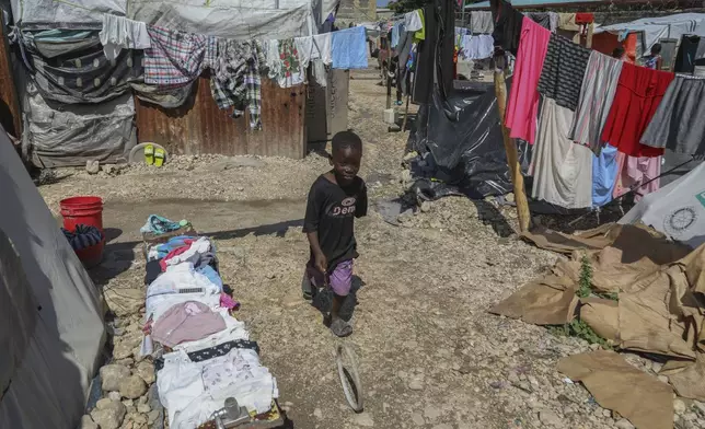 A youth plays with a ring at the end of a wire inside a school where people displaced by gang violence have taken refuge for over a year in Port-au-Prince, Haiti, Friday, Sept. 20, 2024. (AP Photo/Odelyn Joseph)