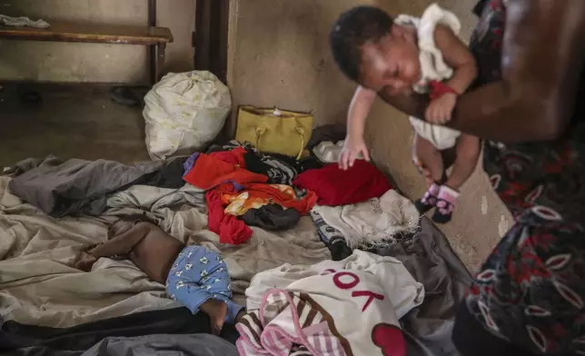 People displaced by armed gang attacks rest at the Antoinette Dessalines National School, a makeshift shelter, in Saint-Marc, Haiti, Sunday, Oct. 6, 2024. (AP Photo/Odelyn Joseph)