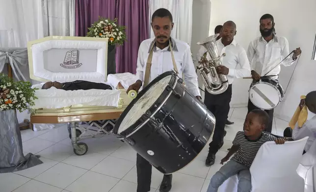 Musicians arrive at the funeral of Jean Louis Jeune Gracien, who was killed during an attack by armed gangs, in Pont-Sonde, Haiti, Tuesday, Oct. 8, 2024. (AP Photo/Odelyn Joseph)