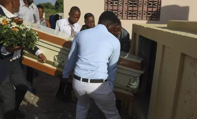 Relatives carry the coffin of Jean Louis Jeune Gracien, who was killed during an attack by armed gangs, at his funeral in Pont-Sonde, Haiti, Tuesday, Oct. 8, 2024. (AP Photo/Odelyn Joseph)