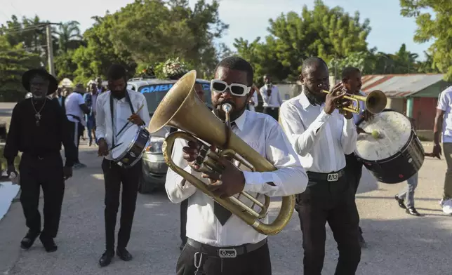 Musicians perform during the funeral of Jean Louis Jeune Gracien, who was killed during an attack by armed gangs, in Pont-Sonde, Haiti, Tuesday, Oct. 8, 2024. (AP Photo/Odelyn Joseph)