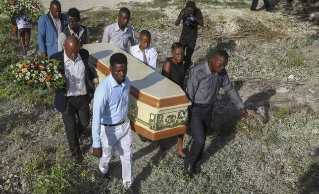 Relatives carry the coffin of Jean Louis Jeune Gracien, who was killed during an attack by armed gangs, at his funeral in Pont-Sonde, Haiti, Tuesday, Oct. 8, 2024. (AP Photo/Odelyn Joseph)