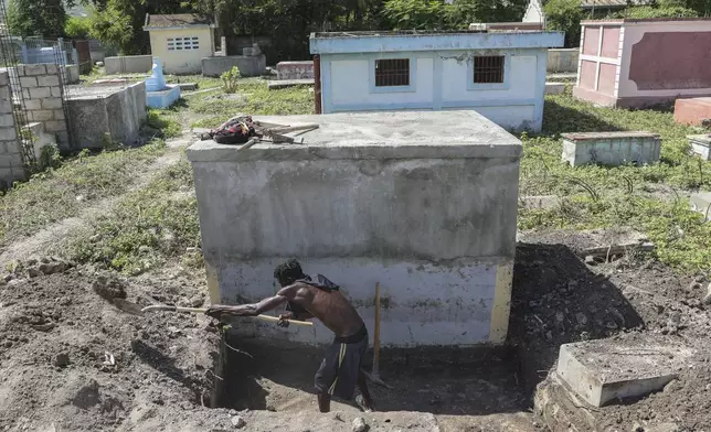 A cemetery worker prepares a grave days after a deadly gang attack on Pont-Sonde, Haiti, Tuesday, Oct. 8, 2024. (AP Photo/Odelyn Joseph)