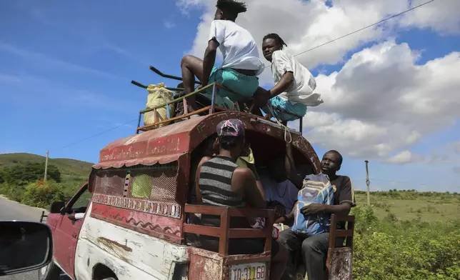 People ride public transportation known as a tap-tap in Pont-Sonde, Haiti, Tuesday, Oct. 8, 2024, days after a deadly gang attack on the town. (AP Photo/Odelyn Joseph)