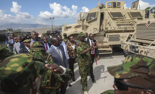 Kenya's President William Ruto, center left, visits Kenyan police, part of a UN-backed multinational force, at their base in Port-au-Prince, Haiti, Saturday, Sept. 21, 2024. (AP Photo/Odelyn Joseph)