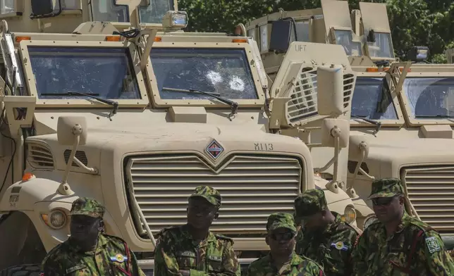 Kenyan police officers, part of a UN-backed multinational force, stand next to armored vehicles on their base during a visit by Kenya's President William Ruto, in Port-au-Prince, Haiti, Saturday, Sept. 21, 2024. (AP Photo/Odelyn Joseph)