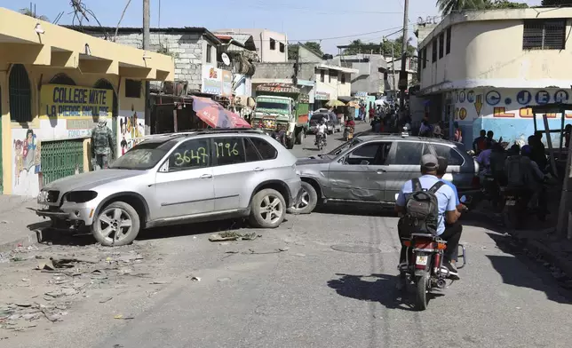 Cars are used as barricades to prevent entry of gang members into the Nazon neighborhood of Port-au-Prince, Haiti, Saturday, Oct. 26, 2024. (AP Photo/Odelyn Joseph)