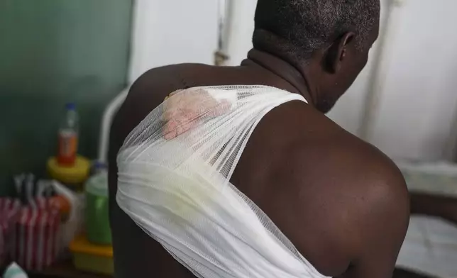 Tcharlit Charles, wounded by a bullet during armed gang attacks, sits on a bed at Saint Nicolas hospital in Saint-Marc, Haiti, Sunday, Oct. 6, 2024. (AP Photo/Odelyn Joseph)