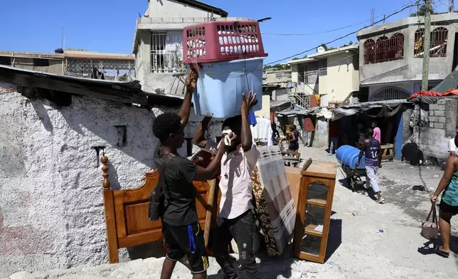 Residents pack up their belongings to flee their homes to escape gang violence in the Solino neighborhood of Port-au-Prince, Haiti, Saturday, Oct. 26, 2024. (AP Photo/Odelyn Joseph)