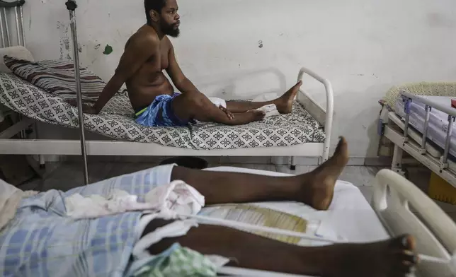 Exiles Junior, wounded by a bullet during armed gang attacks, sits up on a bed at Saint Nicolas hospital in Saint-Marc, Haiti, Sunday, Oct. 6, 2024. (AP Photo/Odelyn Joseph)