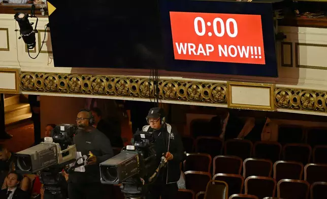 A sign flashes to wrap now as Doug Collins speaks during his enshrinement in the Basketball Hall of Fame, Sunday Oct. 13, 2024, in Springfield, Mass. (AP Photo/Jessica Hill)