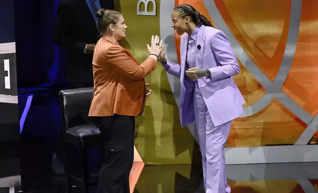 Seimone Augustus, right, slaps hands with Lindsay Whalen, left, during her enshrinement in the Basketball Hall of Fame, Sunday Oct. 13, 2024, in Springfield, Mass. (AP Photo/Jessica Hill)