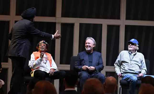 Toronto Raptors superfan Nav Bhatia, left, speaks to comedian Billy Crystal, second from right, as film director Spike Lee, second from left, and businessman Alan Horwitz, right, look on at a superfan ceremony at the Basketball Hall of Fame, Sunday, Oct. 13, 2024, in Springfield, Mass. Crystal, Lee, Horwitz and actor Jack Nicholson are being added to the Naismith Memorial Basketball Hall of Fame's James F. Goldstein SuperFan Gallery. (AP Photo/Jessica Hill)