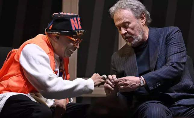 Film director Spike Lee, left, and comedian Billy Crystal, right, compare rings as they are honored at a superfan ceremony at the Basketball Hall of Fame, Sunday, Oct. 13, 2024, in Springfield, Mass. Lee, Crystal, actor Jack Nicholson and businessman Alan Horwitz are being added to the Naismith Memorial Basketball Hall of Fame's James F. Goldstein SuperFan Gallery. (AP Photo/Jessica Hill)