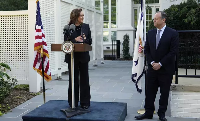 Democratic presidential nominee Vice President Kamala Harris speaks as second gentleman Doug Emhoff looks on before planting a memorial tree on the grounds of the Vice President's residence in Washington on Monday, Oct. 7, 2024, to honor the victims and mark one year since the Oct. 7, 2023, Hamas attack on Israel. (AP Photo/Ben Curtis)