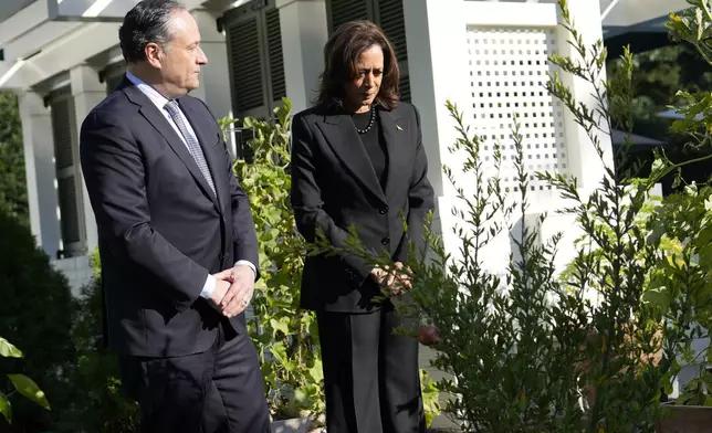 Democratic presidential nominee Vice President Kamala Harris, right, and second gentleman Doug Emhoff stand after planting a memorial tree on the grounds of the Vice President's residence in Washington on Monday, Oct. 7, 2024, to honor the victims and mark one year since the Oct. 7, 2023, Hamas attack on Israel. (AP Photo/Ben Curtis)