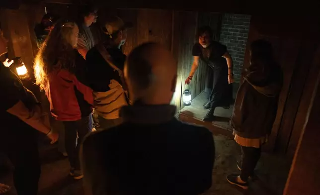 Natasha Cimmiyotti, second from right, talks about trap doors as she leads a tour of underground passages on Thursday, Oct. 17, 2024, in Portland, Ore. (AP Photo/Jenny Kane)