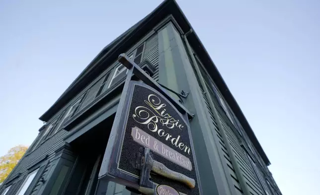 A sign featuring an axe hangs outside the Lizzie Borden House, Wednesday, Oct. 16, 2024, site of an 1892 double axe murder, in Fall River, Mass. (AP Photo/Steven Senne)