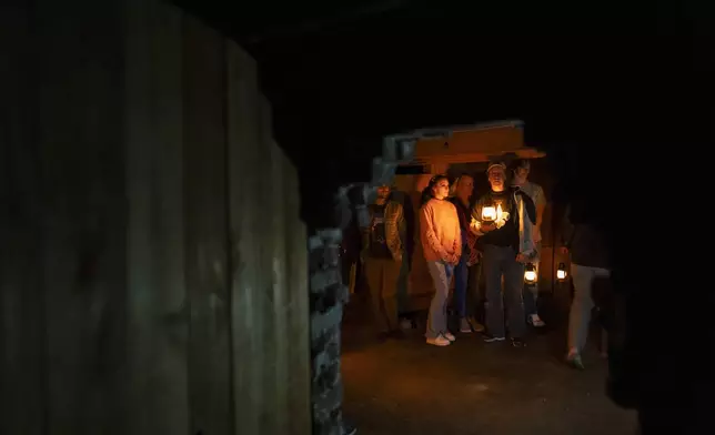 Steve Graham, right, and his daughter Sam Graham, left, look through a passage way during a tour of underground passages on Thursday, Oct. 17, 2024, in Portland, Ore. (AP Photo/Jenny Kane)