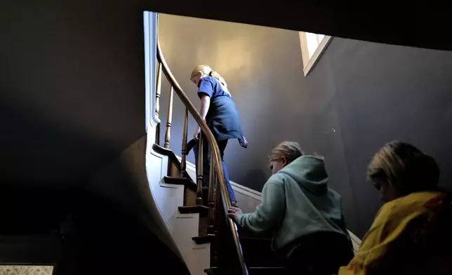 Visitors climb a spiral staircase, Wednesday, Oct. 16, 2024, while touring the Lizzie Borden House, site of an 1892 double axe murder, in Fall River, Mass. (AP Photo/Steven Senne)