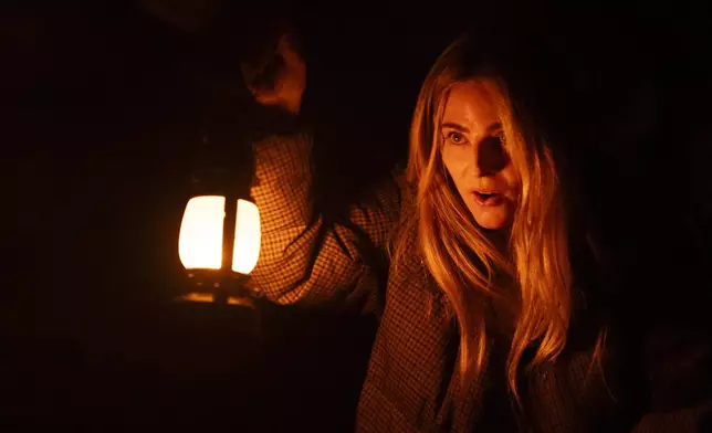 Vanessa Kramer uses a lantern to watch her head for pipes as she makes her way through a tunnel during a tour of underground passages on Thursday, Oct. 17, 2024, in Portland, Ore. (AP Photo/Jenny Kane)