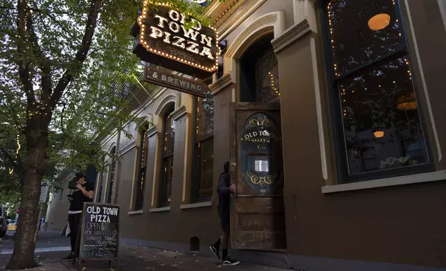 A person enters Old Town Pizza on Thursday, Oct. 17, 2024, in Portland, Ore. (AP Photo/Jenny Kane)