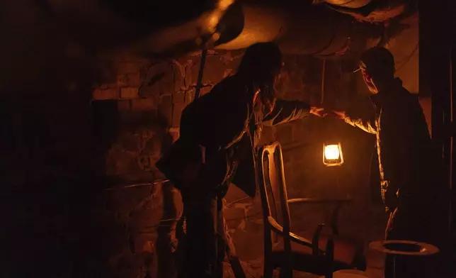 Alyssa Jauregui, left, and Steven Ochoaon hold a lantern to look at an area during a tour of underground passages on Thursday, Oct. 17, 2024, in Portland, Ore. (AP Photo/Jenny Kane)