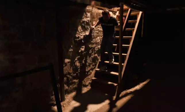 Adam Milne, owner of Old Town Pizza, walks down a staircase to an underground passage area on Thursday, Oct. 17, 2024, in Portland, Ore. (AP Photo/Jenny Kane)