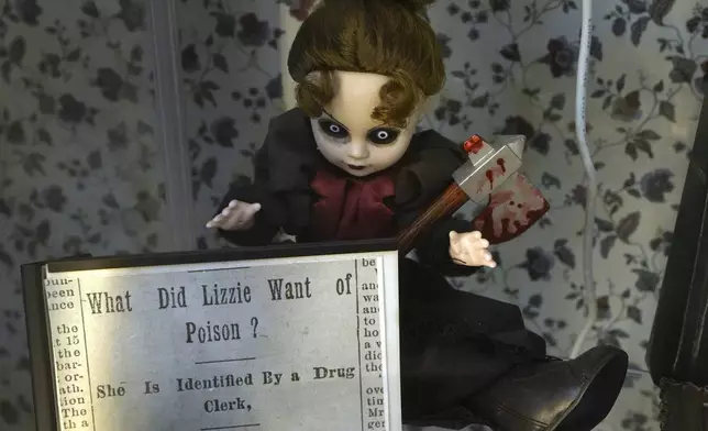 A figurine holding a likeness of an axe rests in a display case, Wednesday, Oct. 16, 2024, at the Lizzie Borden House, site of an 1892 double axe murder, in Fall River, Mass. (AP Photo/Steven Senne)