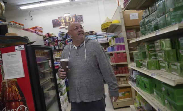 Chad Cummings, a city councilor and co-owner of the local radio stations, walks through Top Asian Food and Deli in Worthington, Minn., on Saturday, Oct. 19, 2024. (AP Photo/Jessie Wardarski)