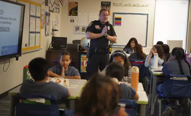 Tyler Olson, a Worthington police officer who also serves as a school resource officer, leads a D.A.R.E. class at the 700-student intermediate school in Worthington, Minn., on Tuesday, Oct. 22, 2024. (AP Photo/Jessie Wardarski)