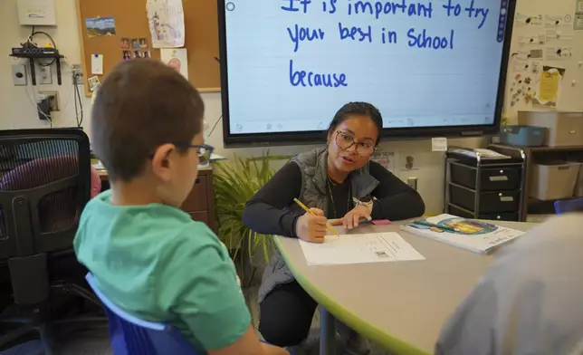 TahSoGhay Collah, right, teaches a third-grade English learners class at the 700-student intermediate school that serves grades 3 through 5, in Worthington, Minn., on Tuesday, Oct. 22, 2024. (AP Photo/Jessie Wardarski)